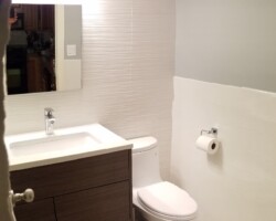 Wall tiles installed up to the ceiling on front wall.