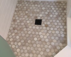 Extended shower room with mosaic tiles on the floor.