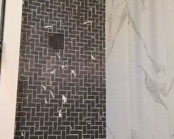 Square drain grill and marble mosaic.