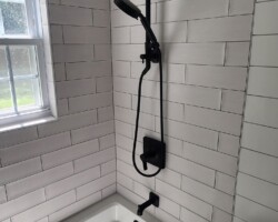 Black shower trim om white tile looks classic.