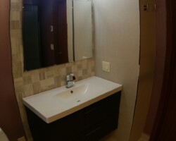 Tiled corner for vanity instead of simple backsplash.