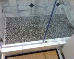 Step to shower made of the same marble tiles.