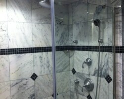 Shower system with hand shower and overhead shower on the ceiling.