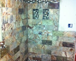 Shower has a couple niches and accent mosaic stripe.