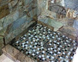 Step to shower made of marble tiles.